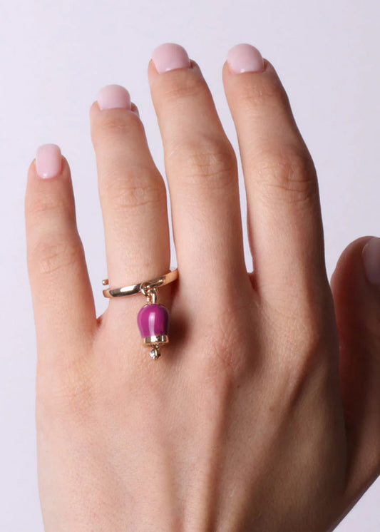 Gold-colored metal ring with purple pendant lucky bell and light point