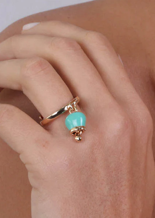 Gold-colored metal ring with a turquoise pendant lucky bell and a light point