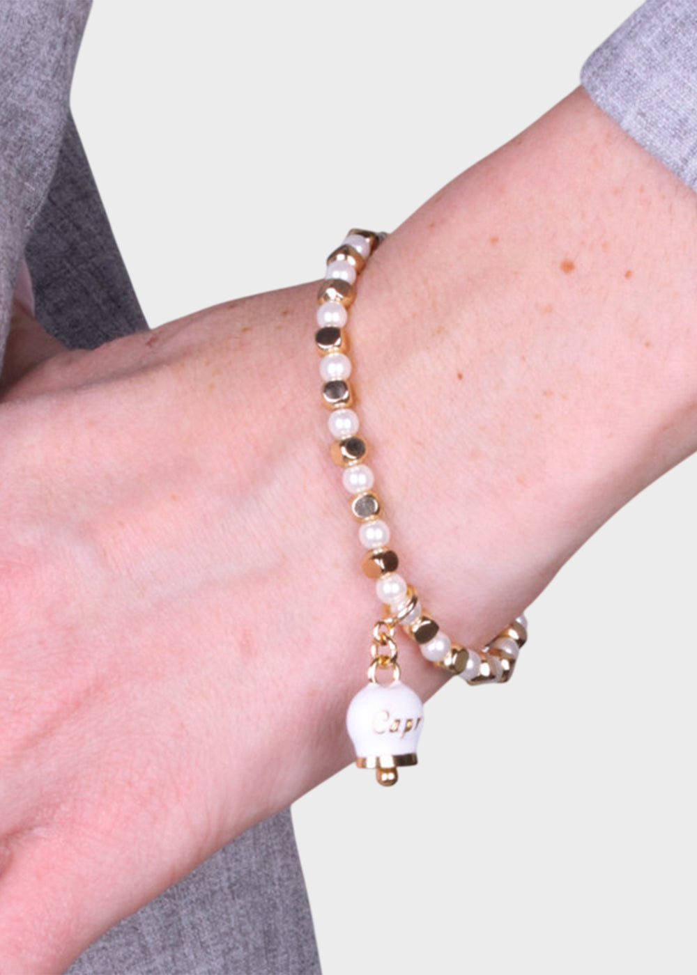 Bracciale in Metallo color oro con sfere, cubi e campanella Capri bianca