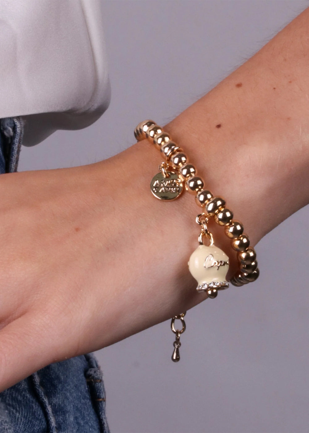 Bracciale in Metallo color oro con maglia a sfere e campanella Capri crema