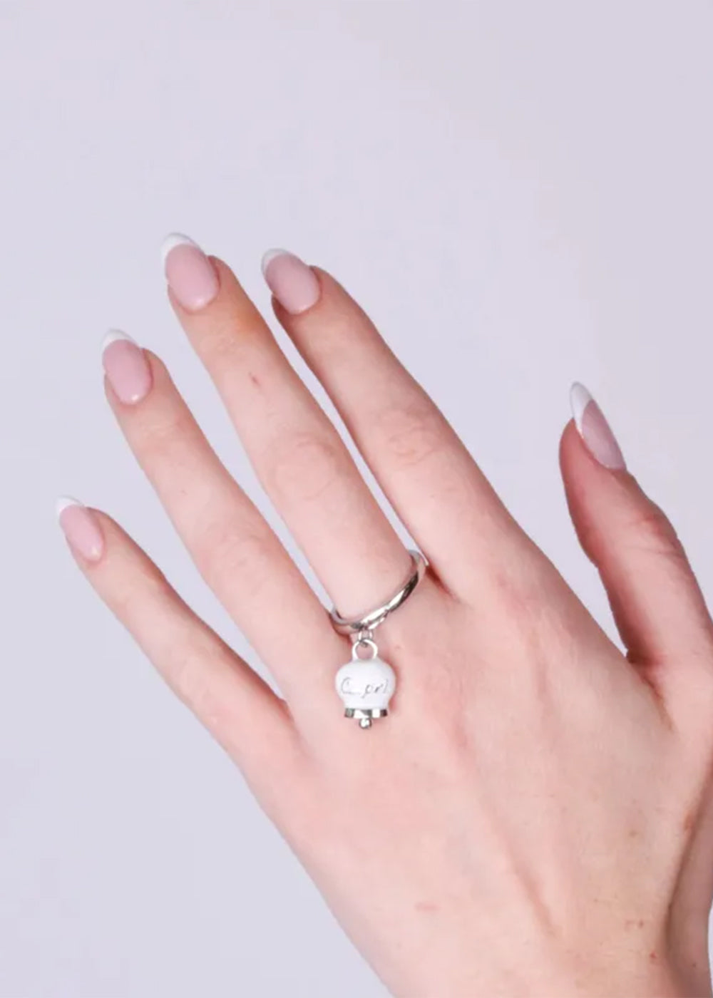 Anello in Acciaio color argento con campanella pendente bianca con scritta Capri