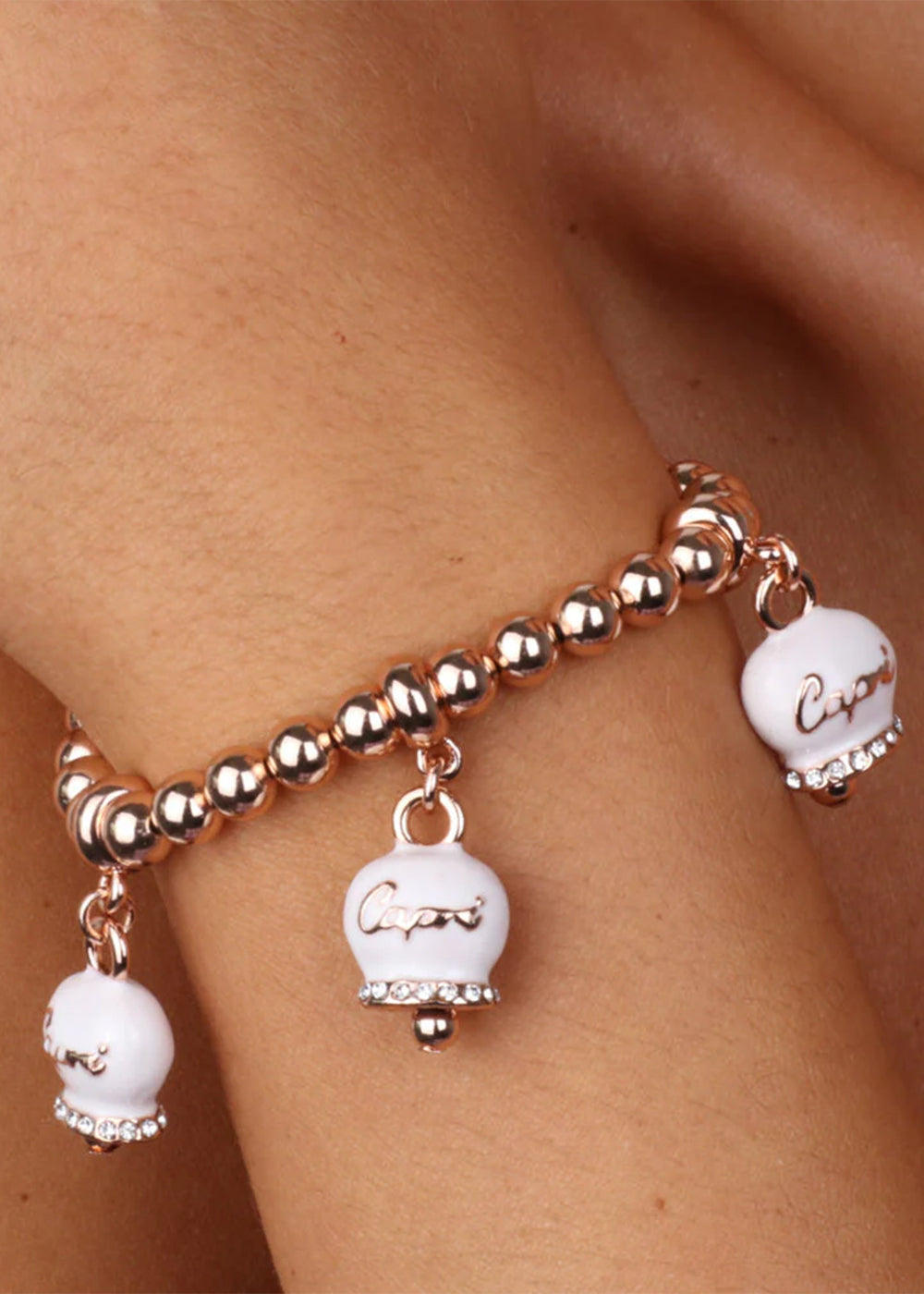 Bracciale in Metallo maglia a sfere color oro rosa con tre campanelle portafortuna bianche e cristalli
