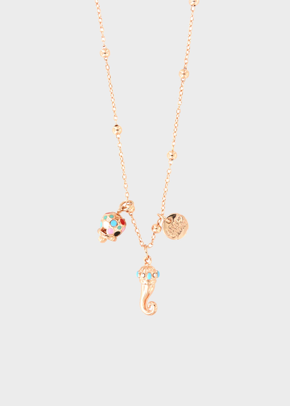 Collana in Metallo color oro rosa con corno pendente impreziosito da punte di smalto turchese e campanella in smalti multicolore