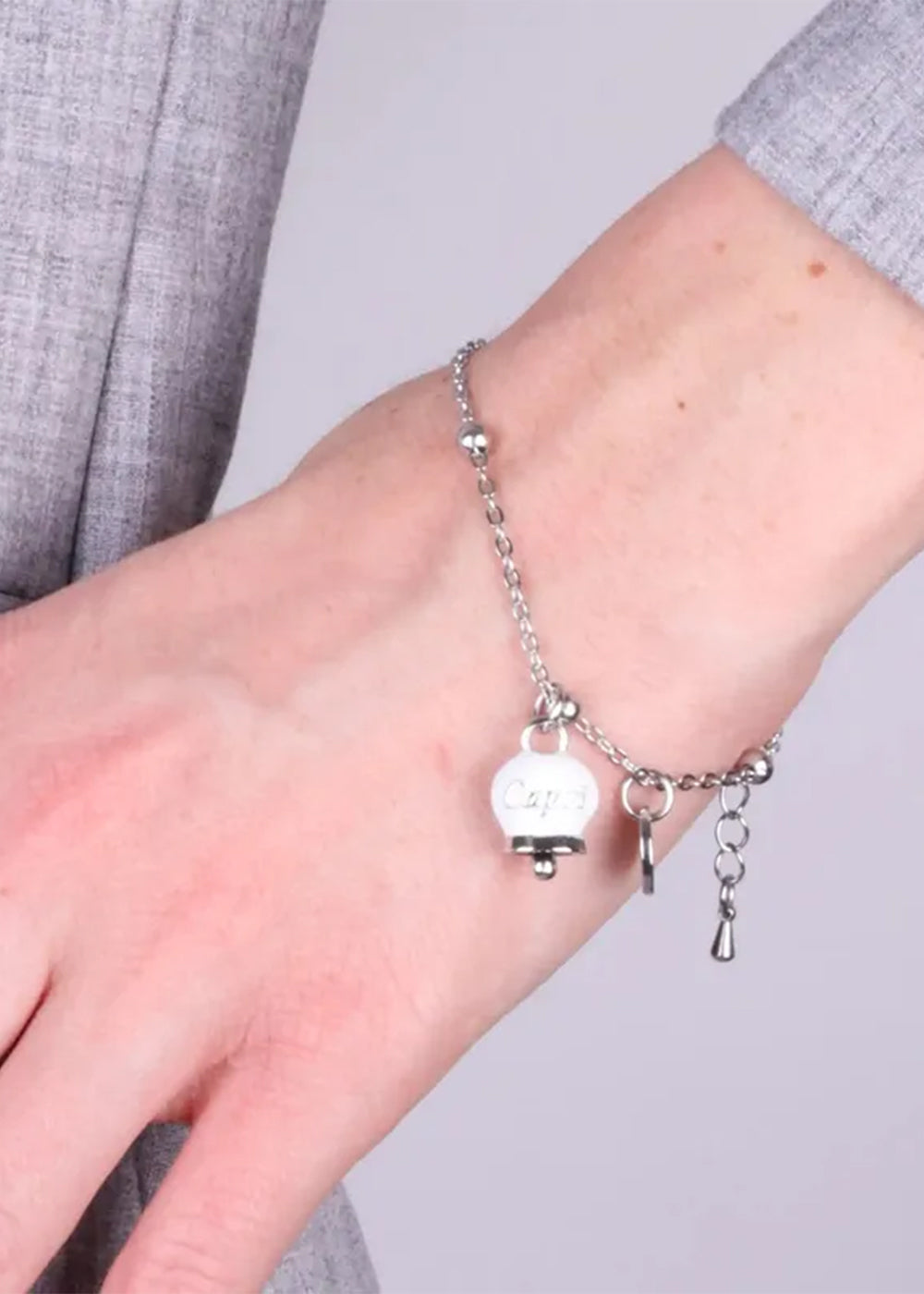 Bracciale in Acciaio color argento con campanella pendente bianca con scritta Capri