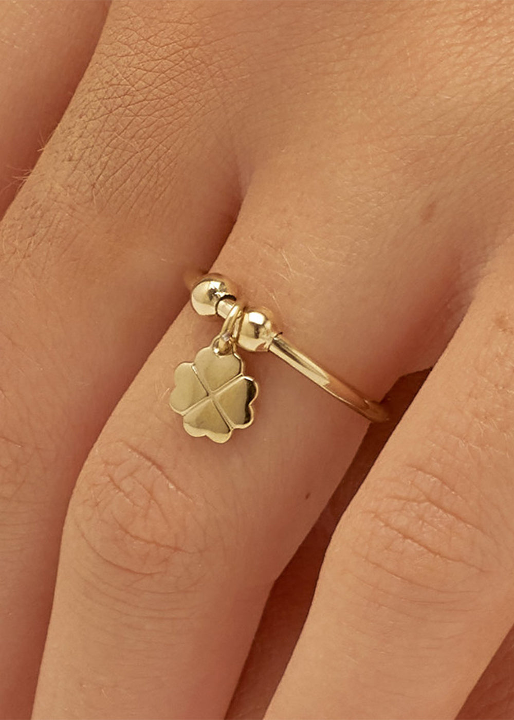Anello regolabile Feelings in acciaio con finitura pvd oro 14K e sfere e pendente a forma di quadrifoglio